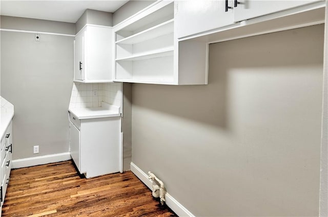 clothes washing area with hardwood / wood-style flooring