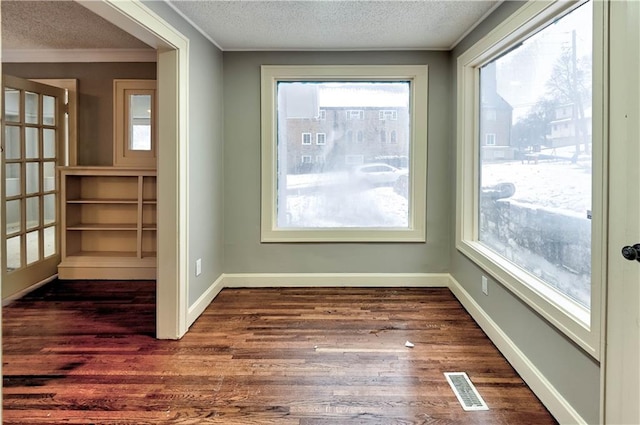 interior space featuring ornamental molding, dark hardwood / wood-style floors, and a textured ceiling