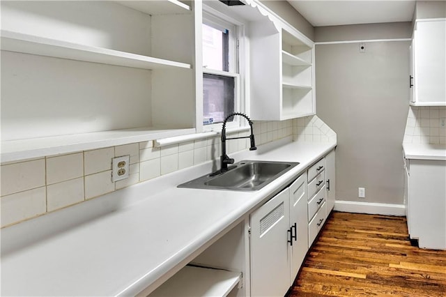 kitchen featuring sink, dark wood-type flooring, white cabinets, and decorative backsplash