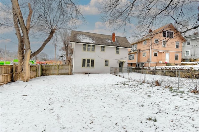 view of snow covered back of property