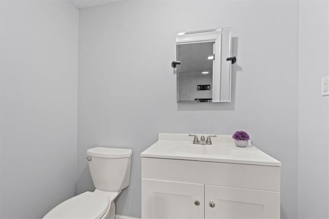 half bathroom featuring toilet and vanity