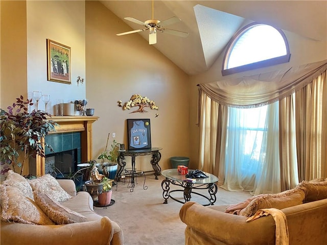 living room with ceiling fan, high vaulted ceiling, carpet flooring, and a tile fireplace