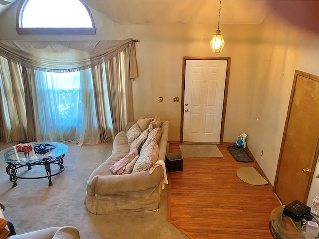 foyer featuring vaulted ceiling, baseboards, and wood finished floors