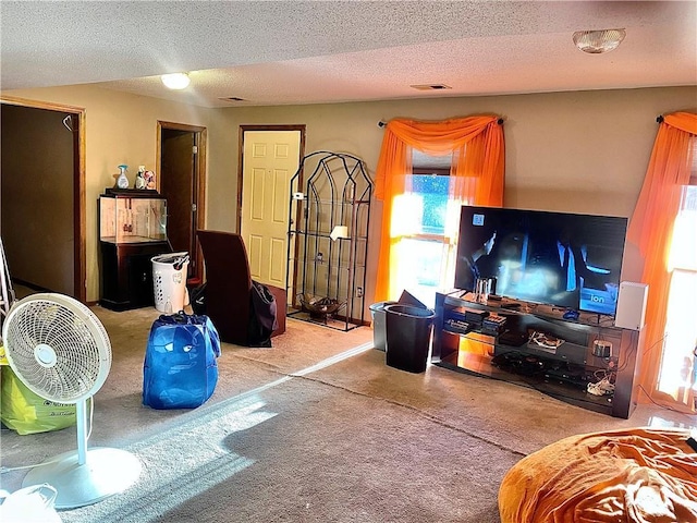 carpeted living area featuring visible vents and a textured ceiling