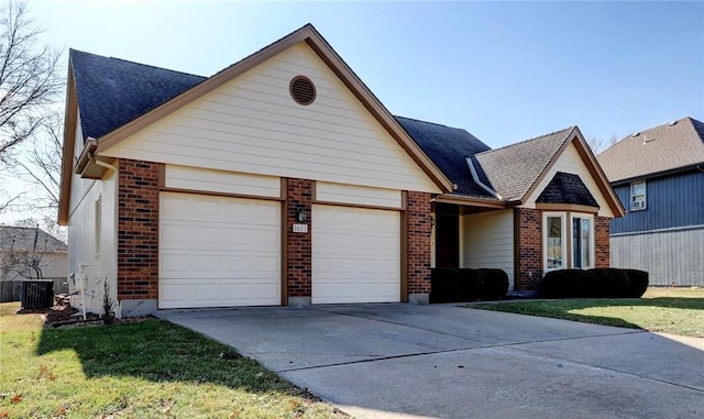 view of front facade with cooling unit, a garage, and a front lawn