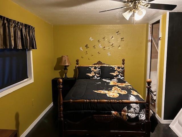 bedroom with ceiling fan and a textured ceiling