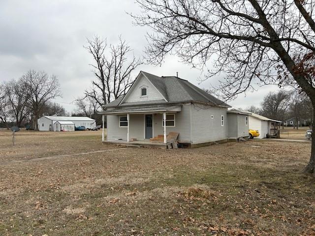 rear view of property featuring a lawn