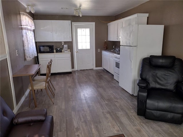 kitchen with sink, white fridge, white cabinets, hardwood / wood-style flooring, and stove