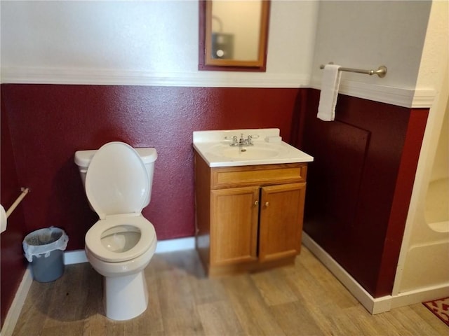 bathroom featuring vanity, hardwood / wood-style flooring, and toilet