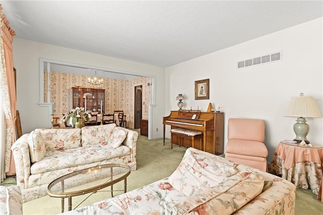 living area with visible vents, a notable chandelier, and light colored carpet