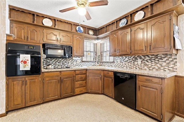 kitchen with black appliances, tasteful backsplash, a sink, and brown cabinets