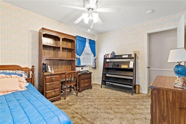 bedroom featuring wallpapered walls, a textured ceiling, a ceiling fan, and light colored carpet