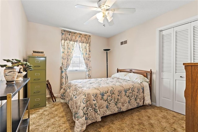 bedroom with a closet, light colored carpet, visible vents, a ceiling fan, and baseboards