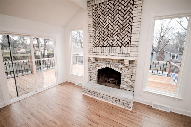 unfurnished living room with wood-type flooring and vaulted ceiling