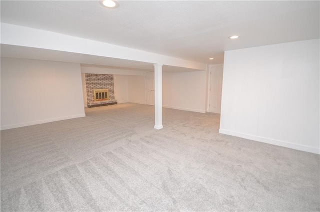 basement featuring light carpet and a fireplace