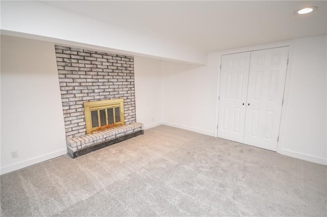 unfurnished living room featuring carpet floors and a brick fireplace