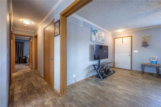 interior space featuring wood finished floors, visible vents, and crown molding