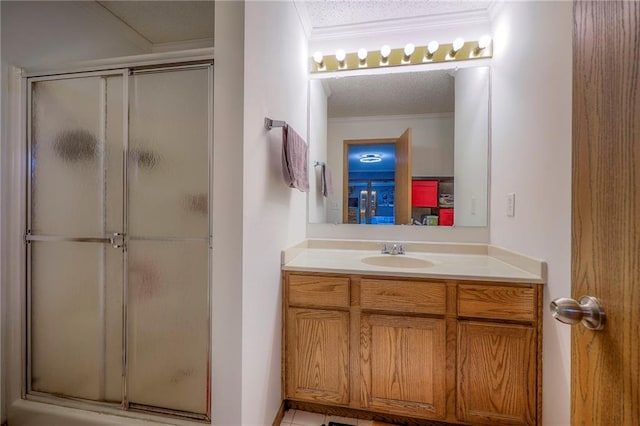 full bathroom with a stall shower, ornamental molding, a textured ceiling, and vanity