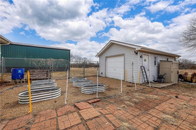 view of patio with a detached garage, fence, and an outdoor structure