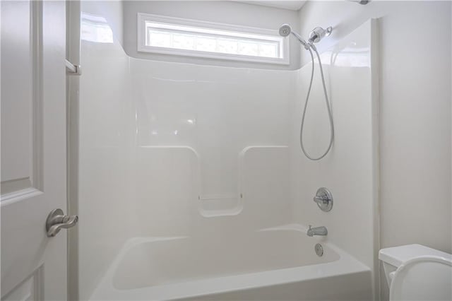 bathroom with shower / bath combination and toilet