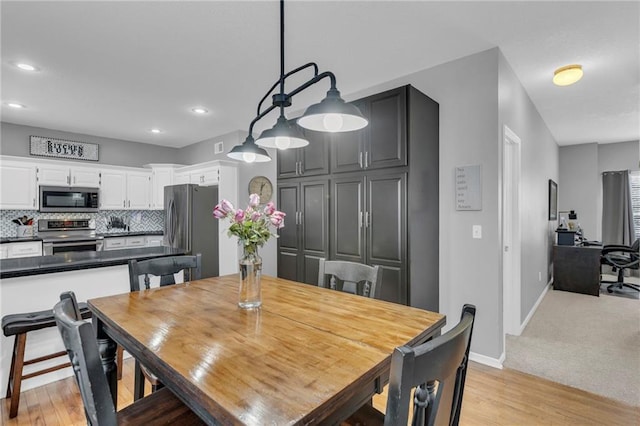 dining space featuring light wood-type flooring, baseboards, and recessed lighting