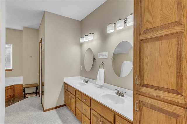 full bath with double vanity, a sink, and baseboards