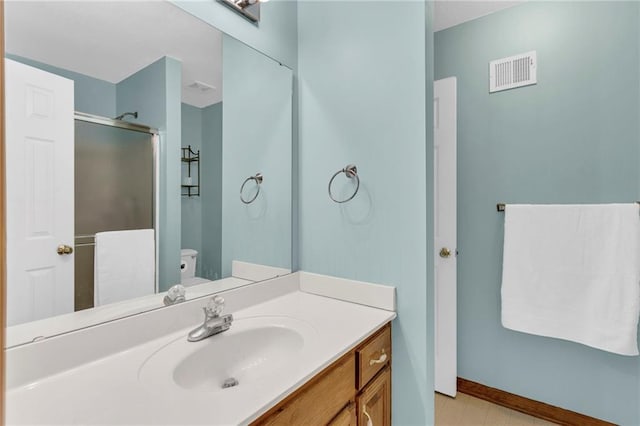 bathroom featuring visible vents, toilet, a stall shower, vanity, and baseboards