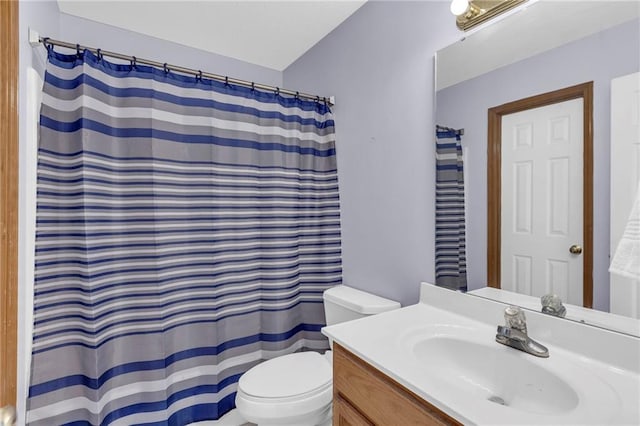 full bath featuring a shower with shower curtain, vanity, and toilet