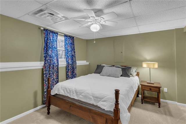 carpeted bedroom featuring baseboards, visible vents, ceiling fan, and a drop ceiling