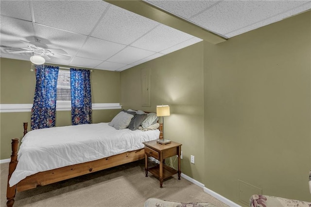 bedroom with a ceiling fan, carpet, a paneled ceiling, and baseboards