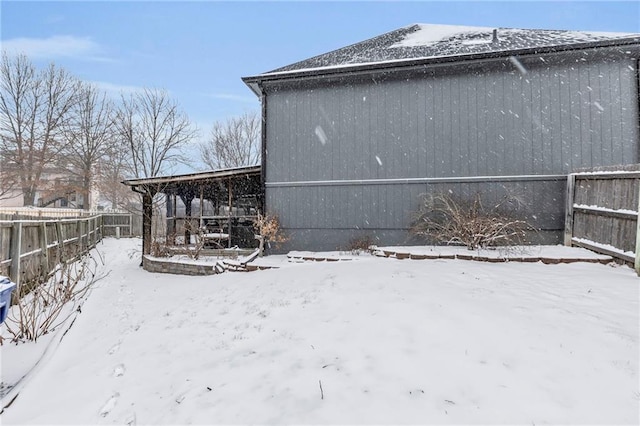 view of snowy exterior with fence