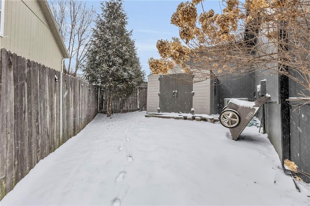 snowy yard featuring fence and an outdoor structure