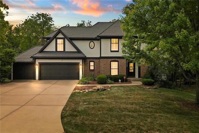 tudor home with a garage and a yard