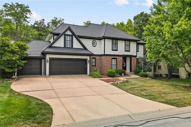 tudor house featuring a garage and a front lawn