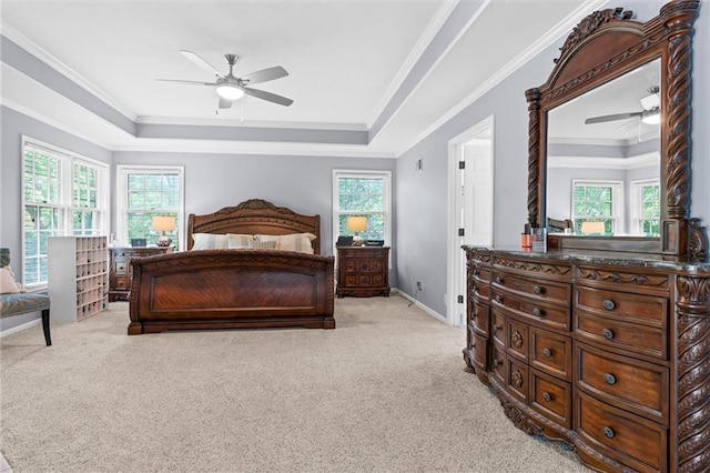 bedroom featuring light carpet, a tray ceiling, and ornamental molding