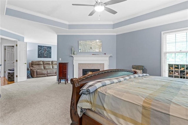 bedroom with crown molding, carpet flooring, a tray ceiling, and ceiling fan