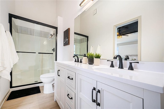 bathroom featuring walk in shower, toilet, vanity, ceiling fan, and hardwood / wood-style floors