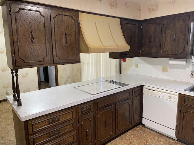 kitchen with extractor fan, a peninsula, white appliances, light countertops, and dark brown cabinets