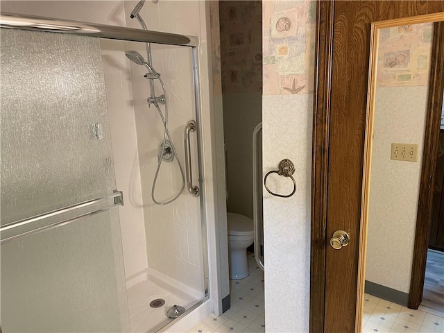 full bathroom with toilet, a stall shower, baseboards, and tile patterned floors