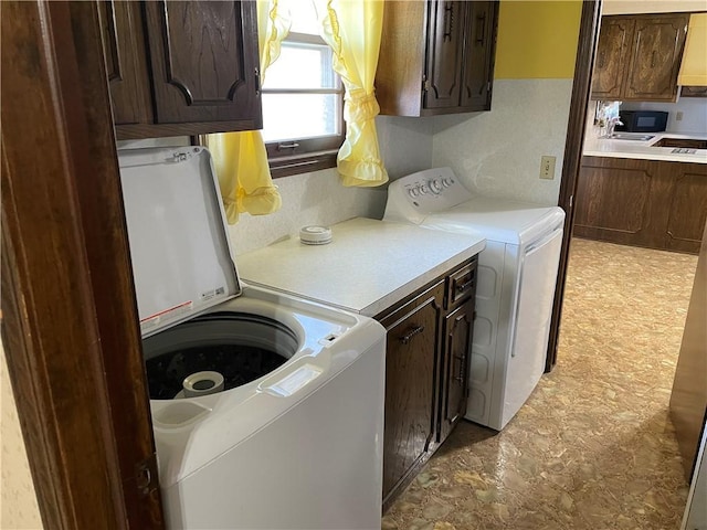 laundry area with washer and clothes dryer, a sink, and cabinet space