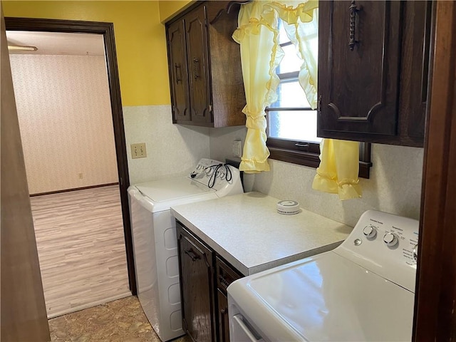 laundry area with baseboards, separate washer and dryer, cabinet space, and wallpapered walls