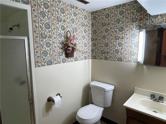 bathroom with a stall shower, vanity, and toilet