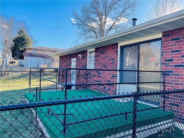 view of side of home with brick siding and fence