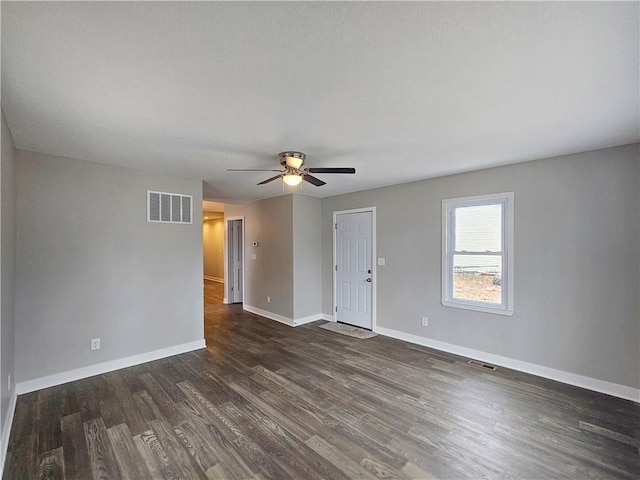 empty room with ceiling fan and dark hardwood / wood-style flooring