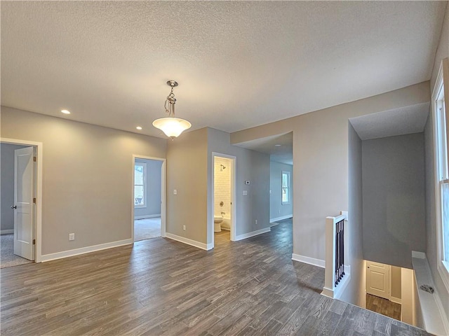 unfurnished room featuring dark wood-type flooring and a textured ceiling