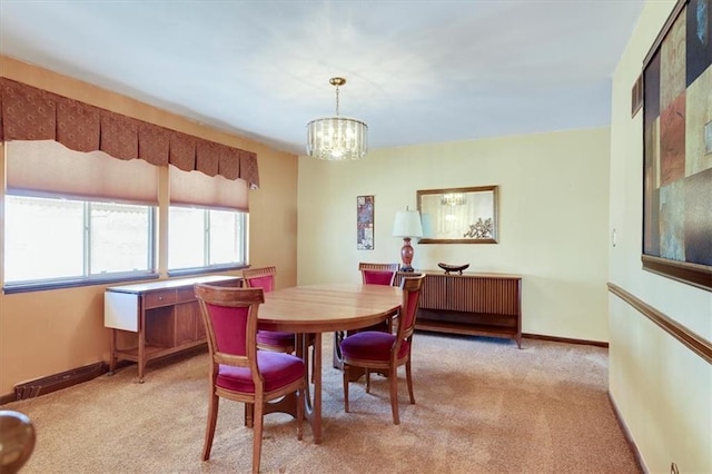 dining space with light carpet, baseboards, and an inviting chandelier