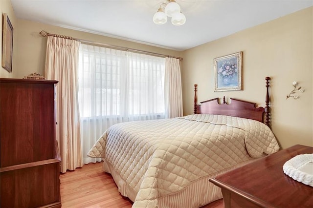 bedroom featuring light wood-type flooring and a notable chandelier