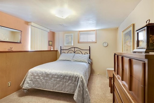 carpeted bedroom featuring wooden walls and visible vents