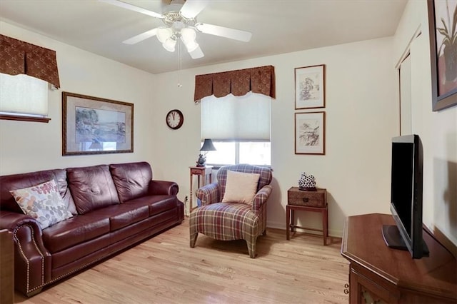 living area featuring light wood-style floors and a ceiling fan