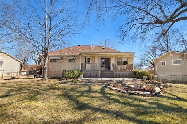 view of front of home with a porch, a front yard, brick siding, and fence